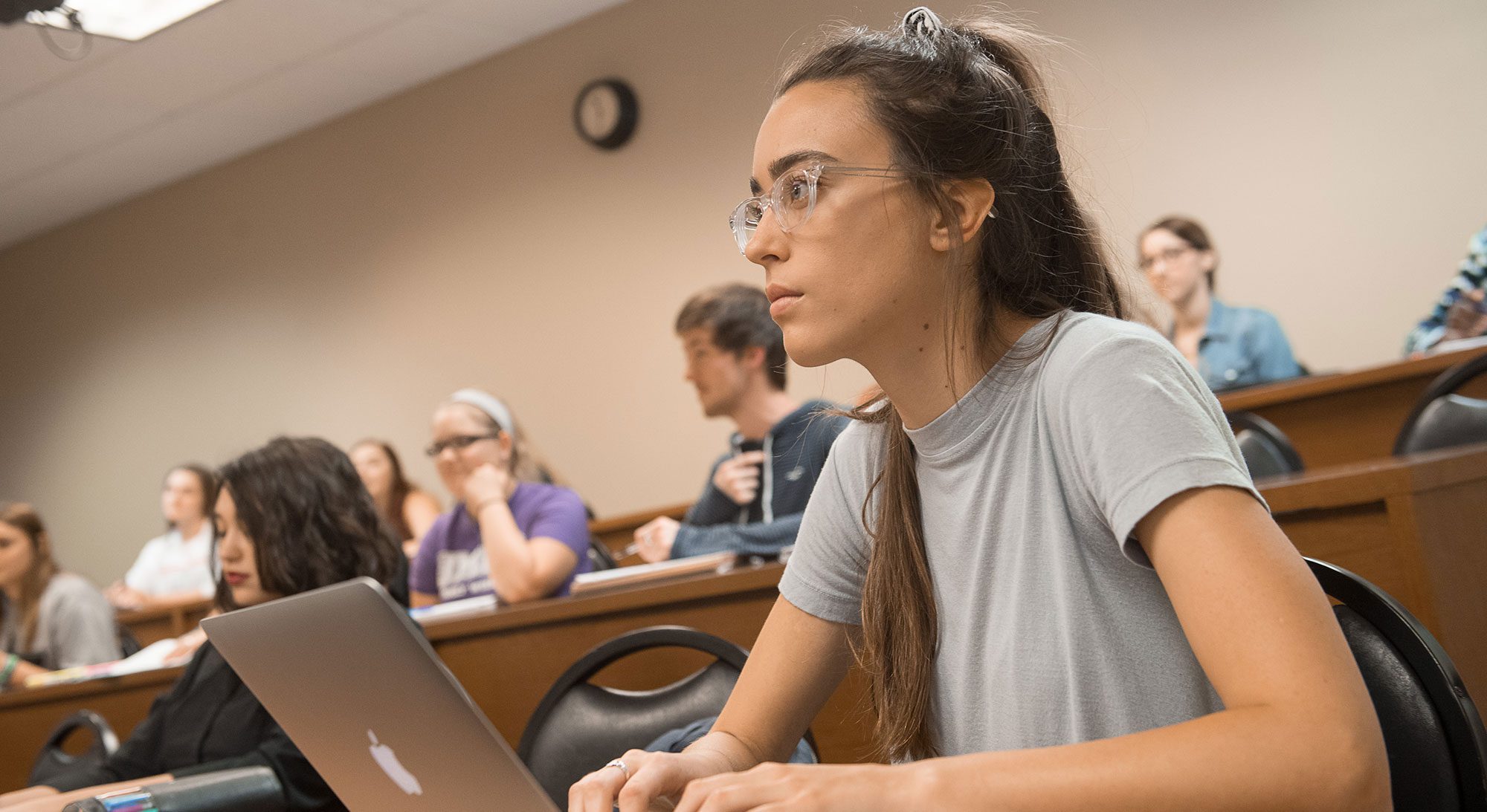 Student is taking notes in class on her laptop