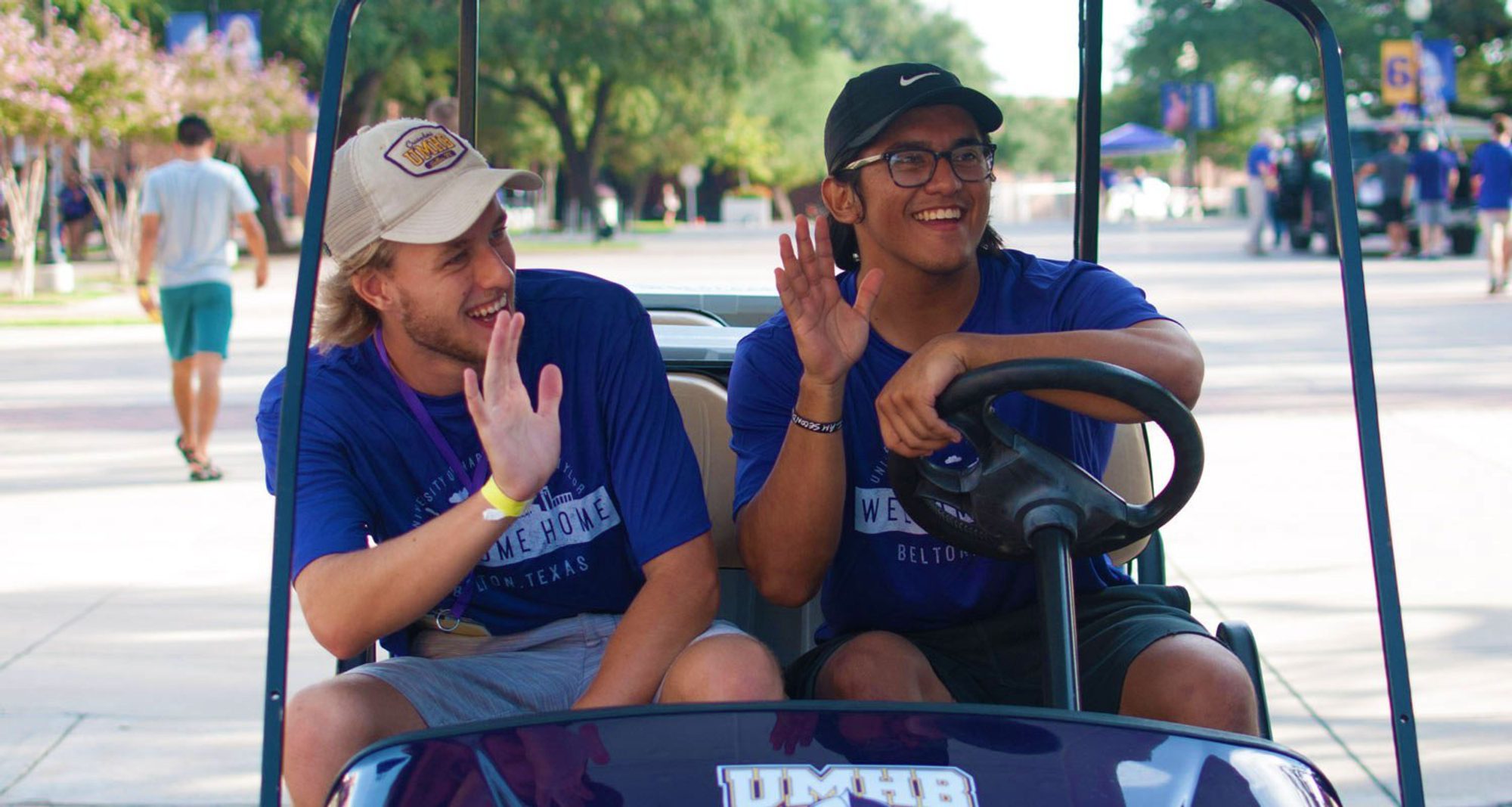 Students in a golf cart on campus Students in a golf cart on campus