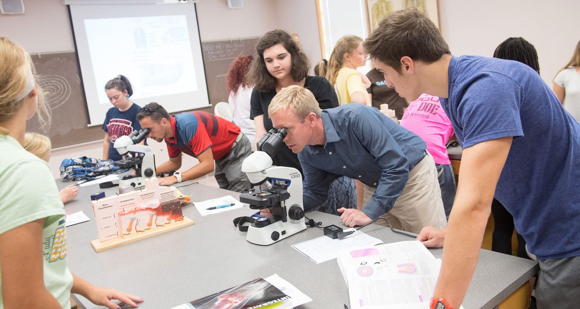 Students getting help with a microscope during a science lab