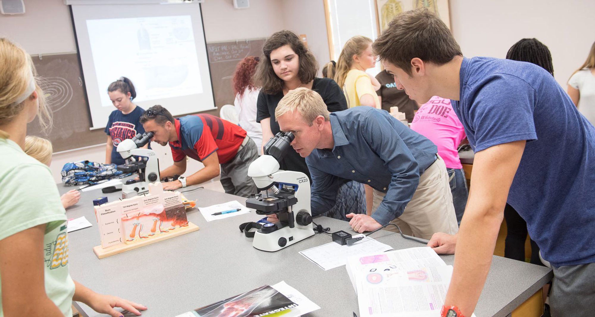Students getting help with a microscope during a science lab Students getting help with a microscope during a science lab