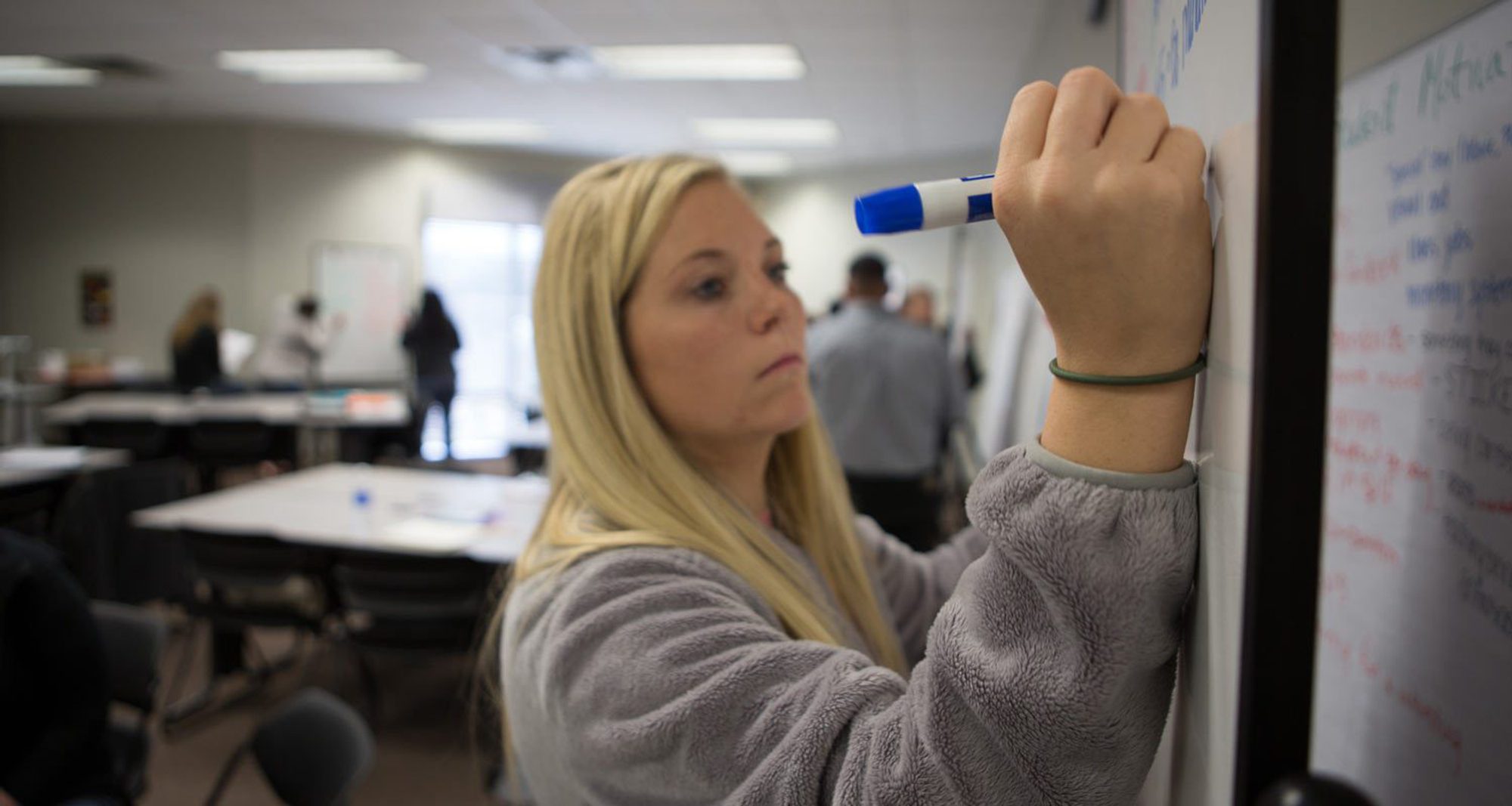 College of Education student writing on whiteboard College of Education student writing on whiteboard