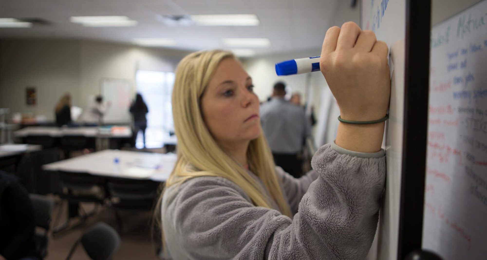 College of Education student writing on whiteboard