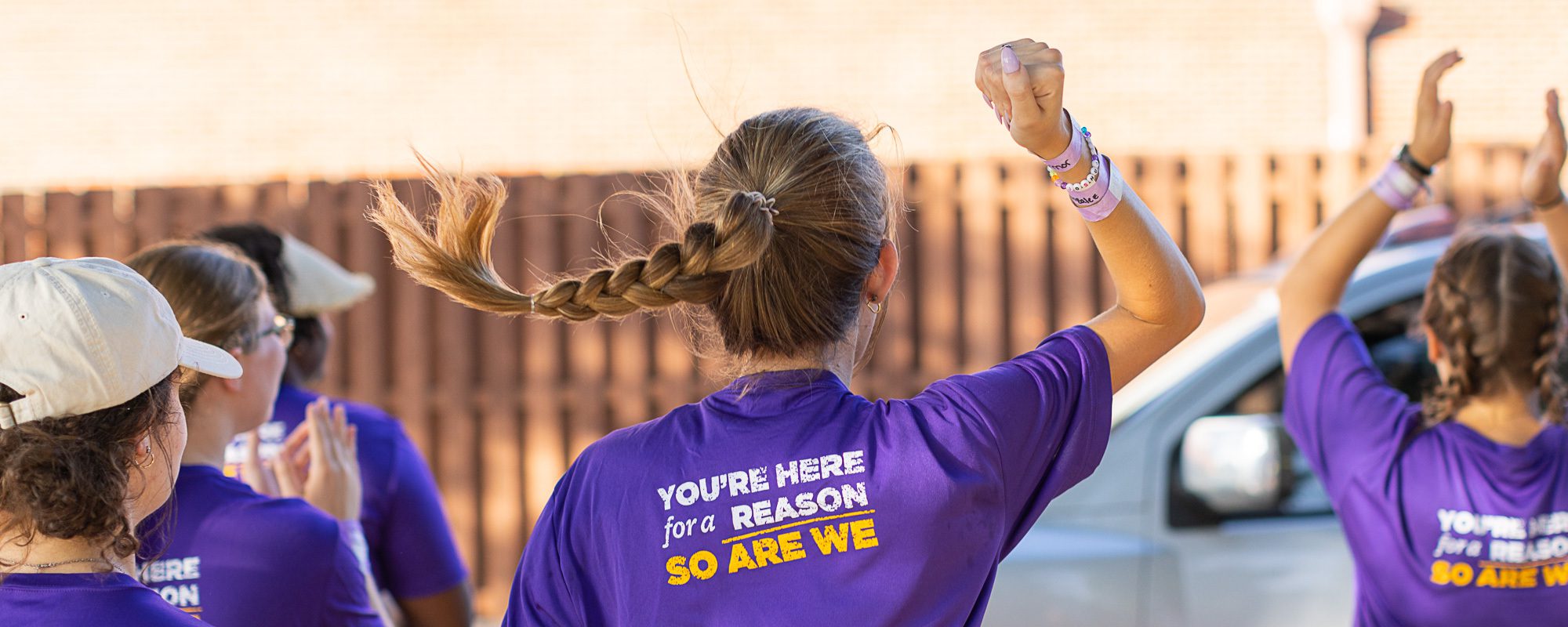 UMHB Students sporting a purple t-shirt of our marketing slogan, you are here for a reason and so are we.