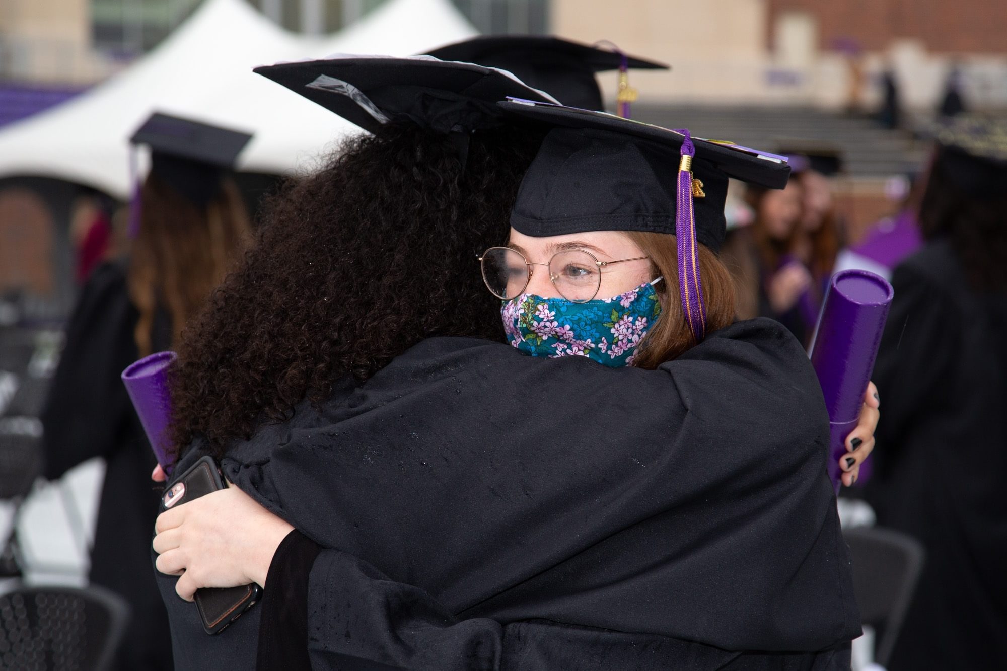 2 female undergraduate students hugging after commencement