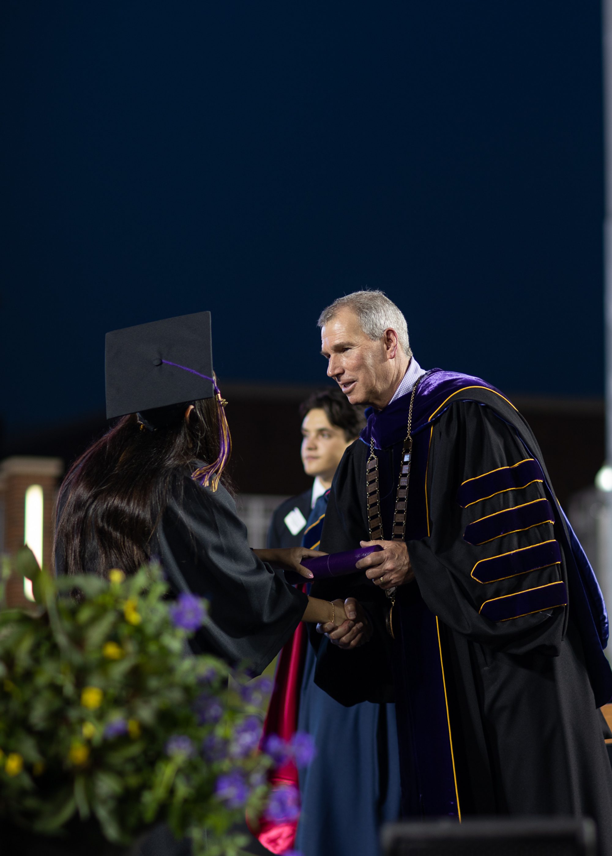 UMHB graduate receiving diploma tube.