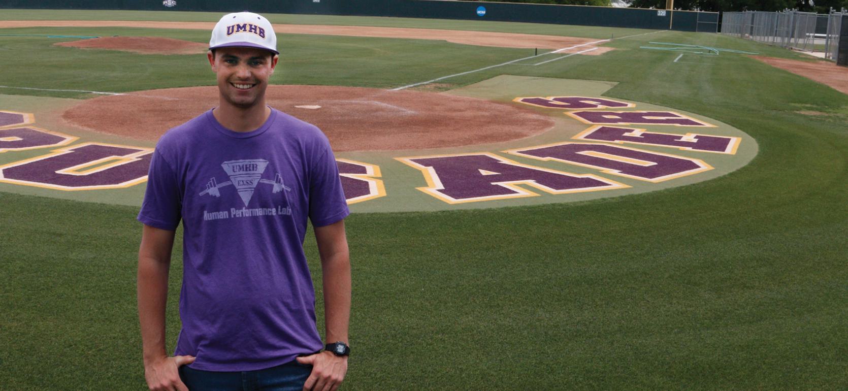 Exercise physiology alum standing near UMHB baseball fields.