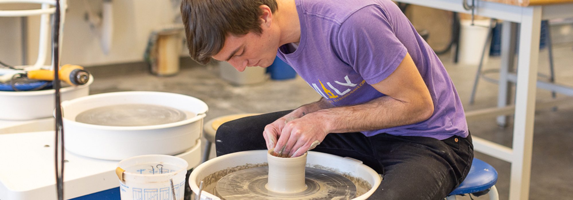 Bachelors of Art student sculpting pottery in art studio at UMHB.