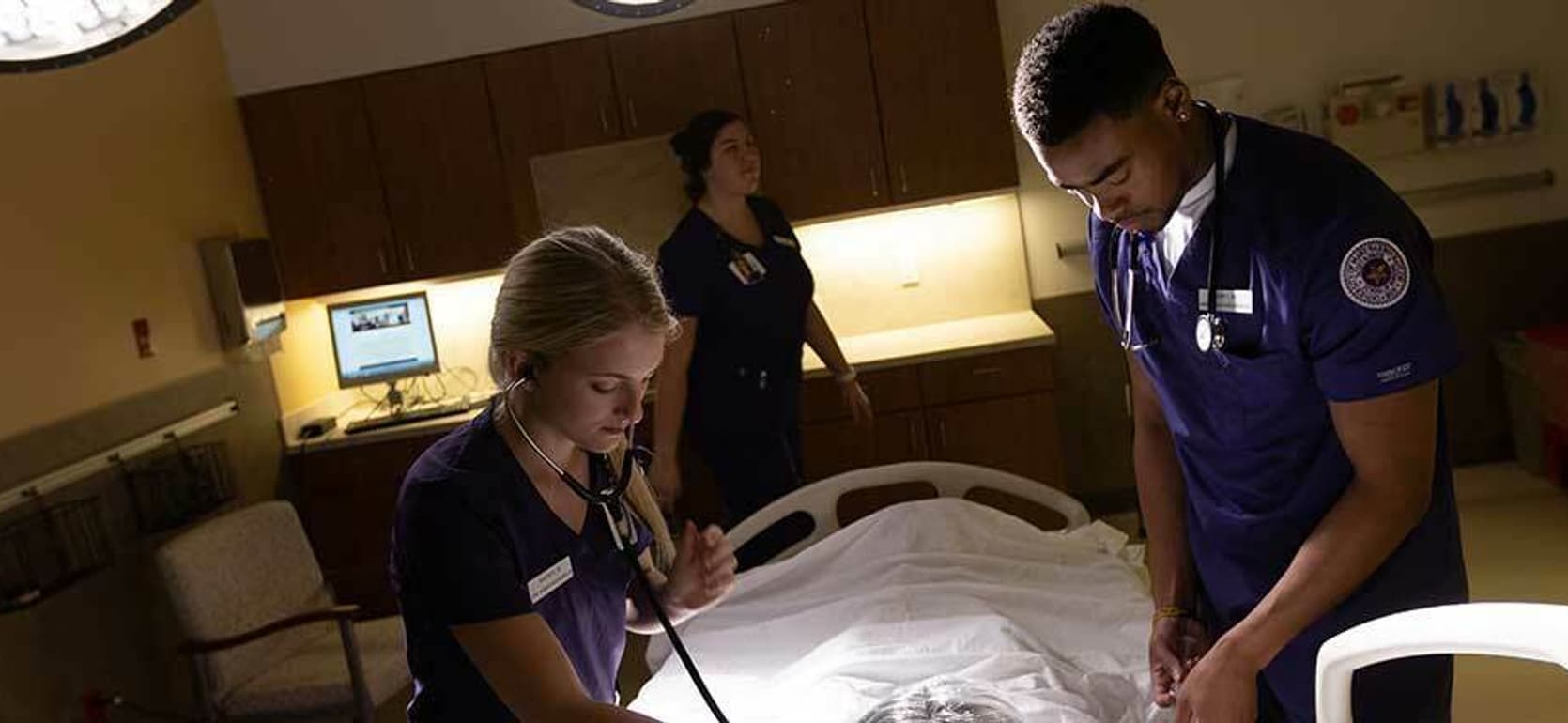 Bachelor of Science in Nursing | BSN students working on patient in nursing training room.