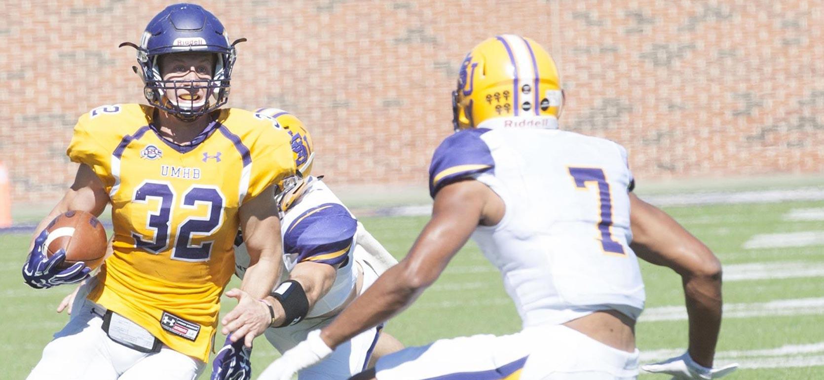 Degree in coaching alumni and 4year football athlete at UMHB avoiding a tackle during a rival game.