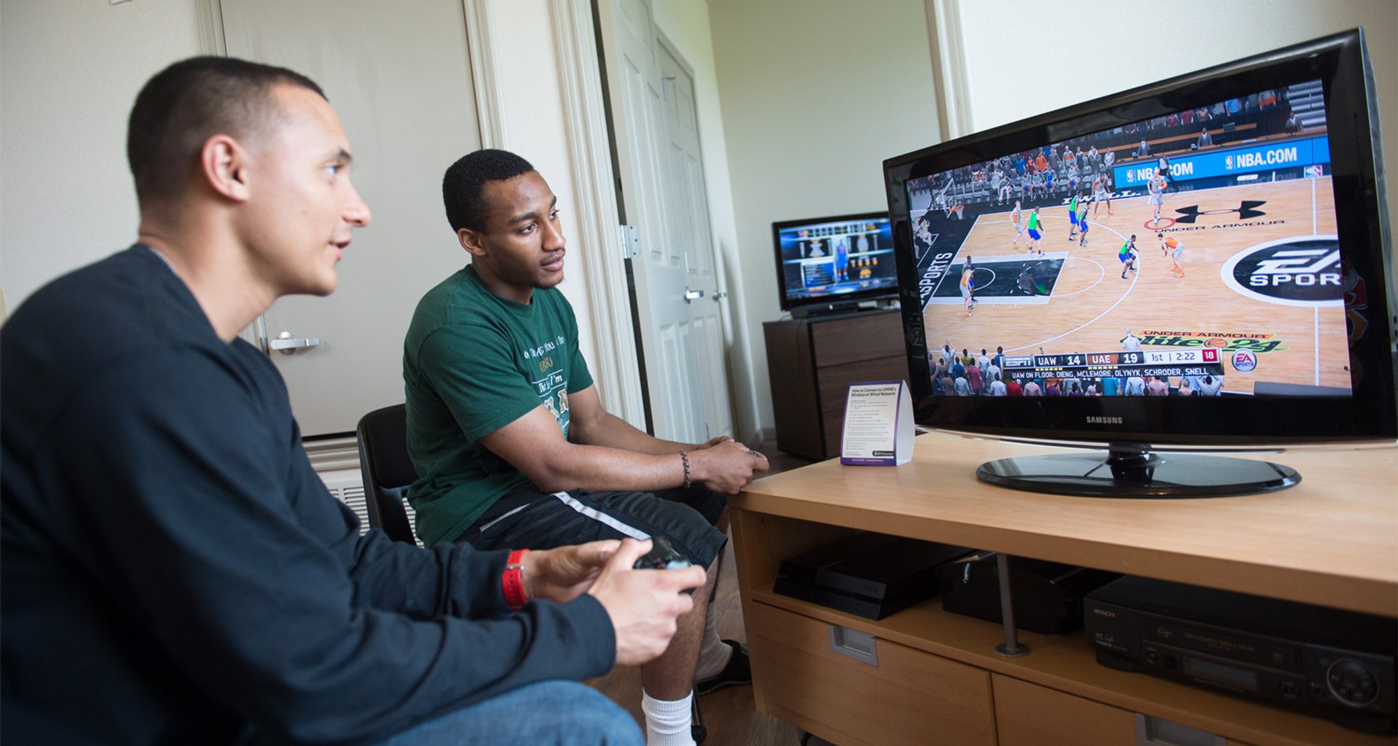 Students play video games in their apartment