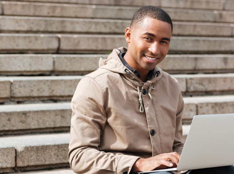 Male sitting on steps with laptop