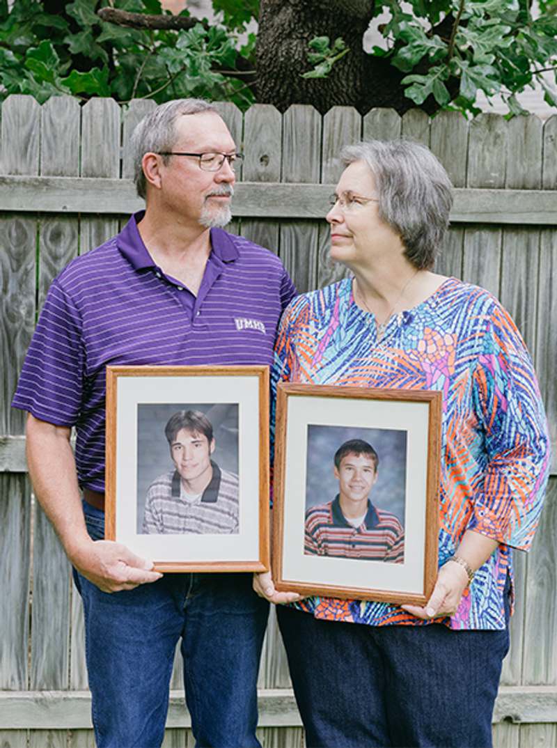 Frank and Diane Schultz holding photos of their beloved sons Jay and Justin.